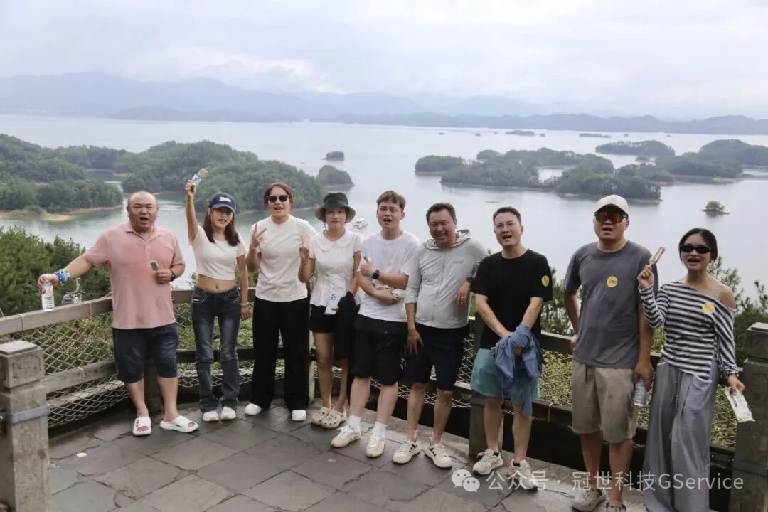 冠世科技同事在千岛湖观景台合影，身后是碧水与星罗棋布的岛屿