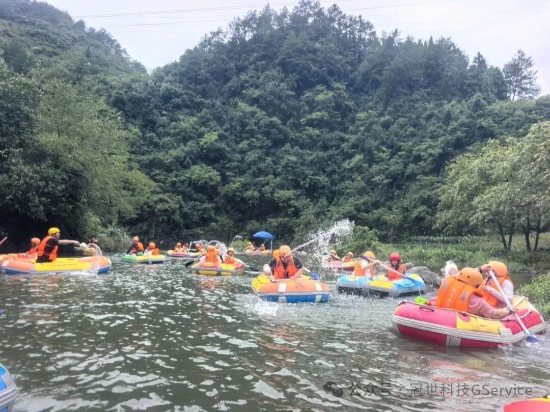 冠世科技同事身穿橙色救生衣分乘多条橡皮筏在溪流中互相泼水嬉戏